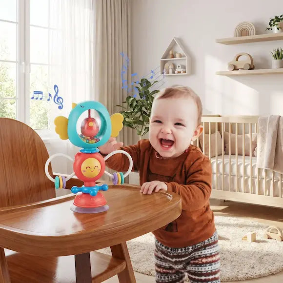 bébé debout près table tend main vers hochet silicone