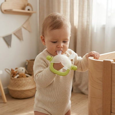 bebe debout tient support bois mordille anneau de dentition vert