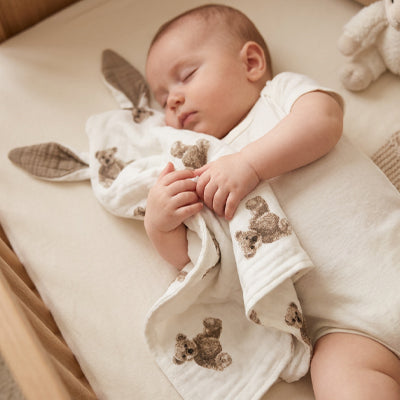 bebe dort avec doudou bebe dans bras