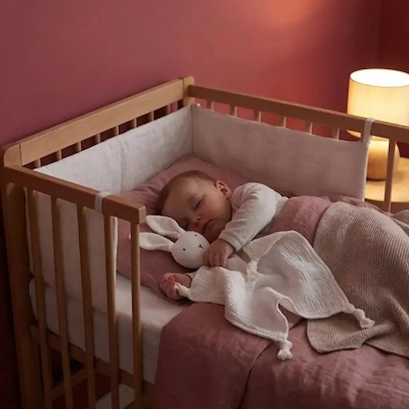 bébé dort berceau avec doudou lapin blanc chambre framboise