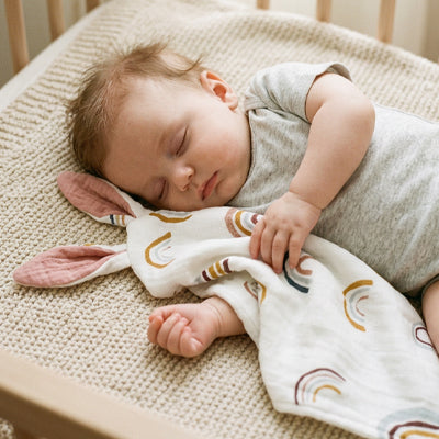 bebe dort berceau doudou bebe oreilles roses dans bras