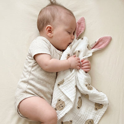 bebe dort lit avec doudou bebe ourson dans bras pres visage