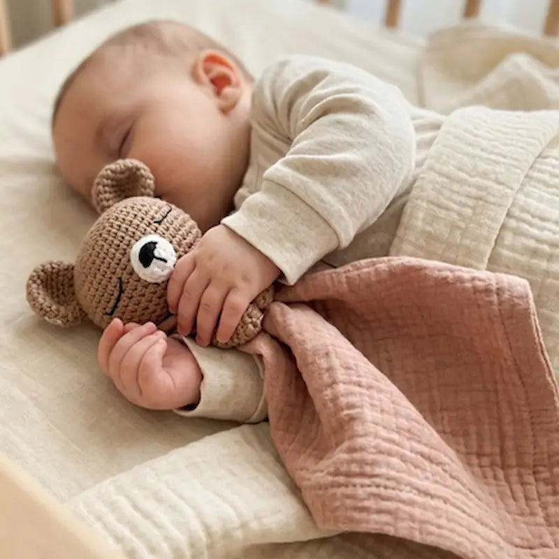 bébé dort sur côté doudou bébé ourson dans bras