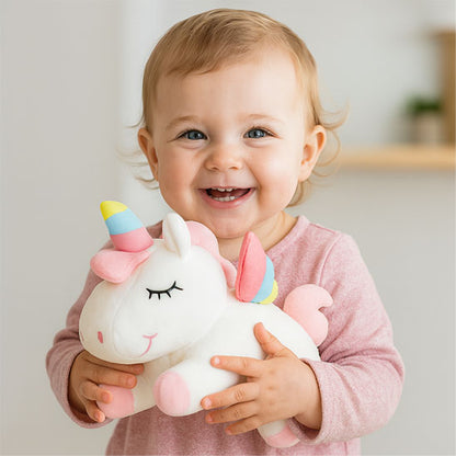 bebe fille tient petite peluche licorne dans mains