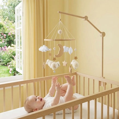 bebe heureux allonge berceau leve mains pieds touche mobile bebe