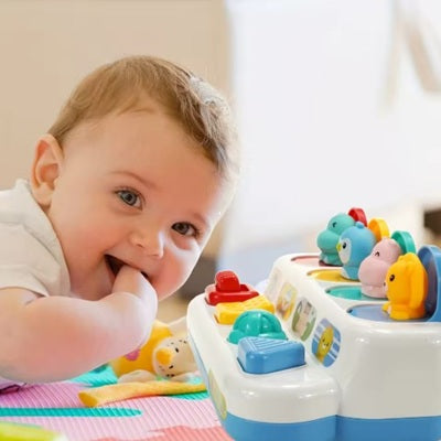 bebe heureux penche sur jouet pour bebe piano vue profil