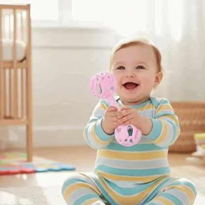 bébé heureux tient hochet bebe rose