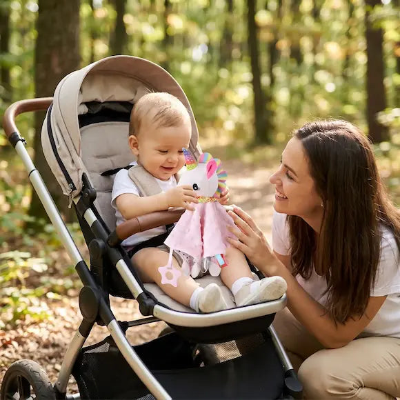 bébé poussette tient doudou bebe maman accroupie sourit bébé