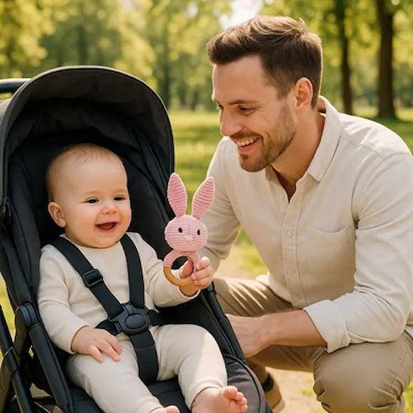 bébé poussette tient hochet bebe papa sourit