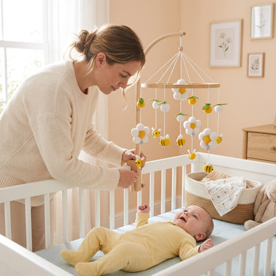 bebe regarde mobile bebe pendant que maman fixe support bois