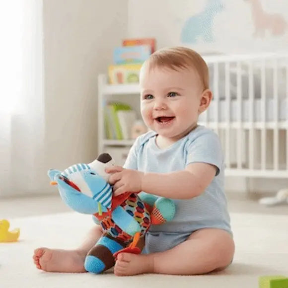 bébé souriant assis tapis tient peluche bebe raton laveur