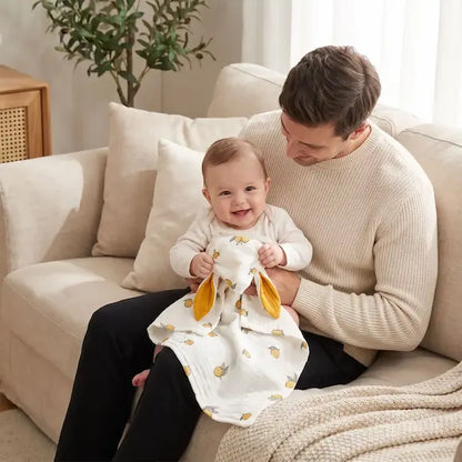 bébé souriant tient doudou bebe assis genou papa canapé