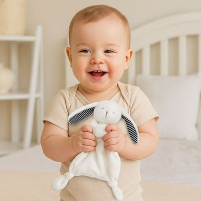 bebe tient doudou bebe entre ses mains