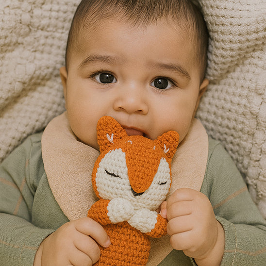 bebe tient doudou bebe renard dans main