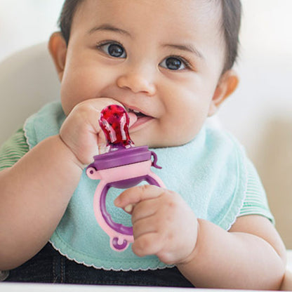 bebe tient grignoteuse bebe avec main droite