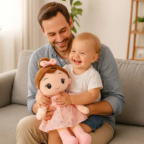 bébé tient poupée de chiffon robe rose sur papa
