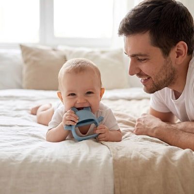 bebe tummy time mord anneau de dentition bebe papa sourit