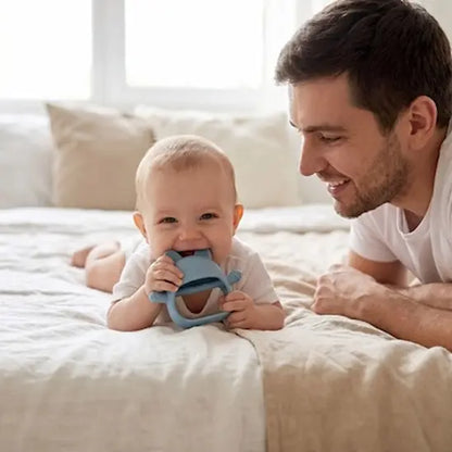 bébé tummy time mord anneau de dentition bébé papa sourit
