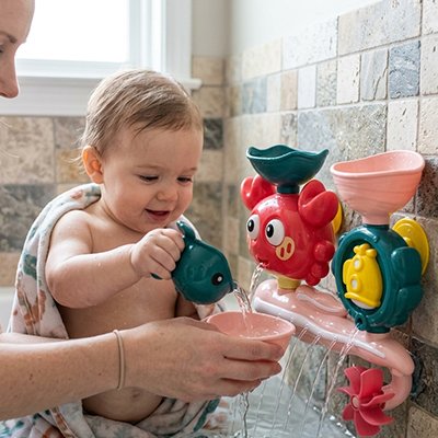 bebe verse eau dans bol jouet baignoire bebe maman tient