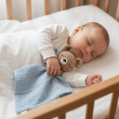 doudou bébé ourson tissu bleu dans bras bébé dort berceau