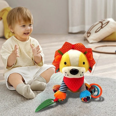enfant assis heureux avec peluche hochet lion