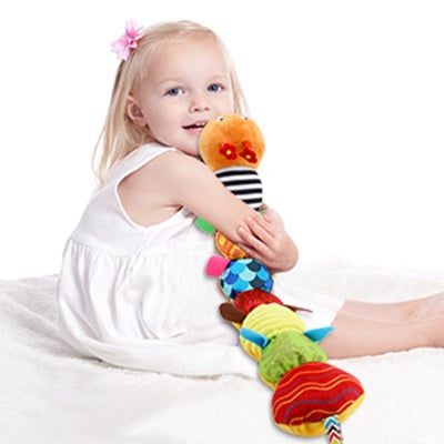 fille fait un calin au hochet chenille orange