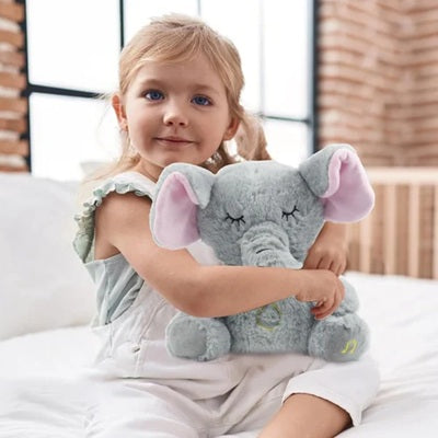 fillette sur lit tient peluche qui respire elephant dans bras
