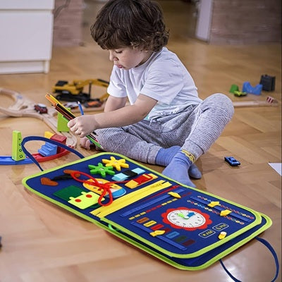 garcon 3 ans joue assis parquet avec busy board bebe