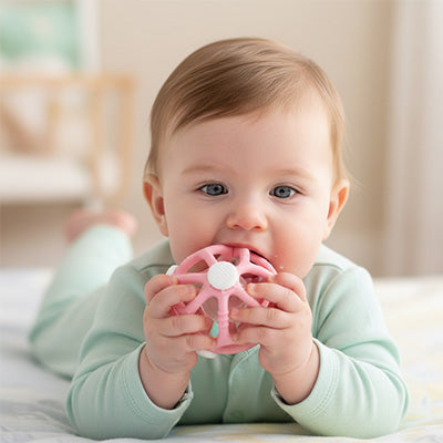 hochet bebe rose dans bouche bebe allonge ventre