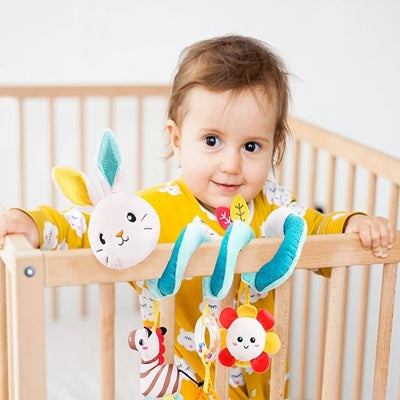 hochet-lapin-installe-autour-barreau-berceau bebe debout dedans heureux