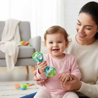 hochet vert bleu tenu par bebe-maman tient bébé