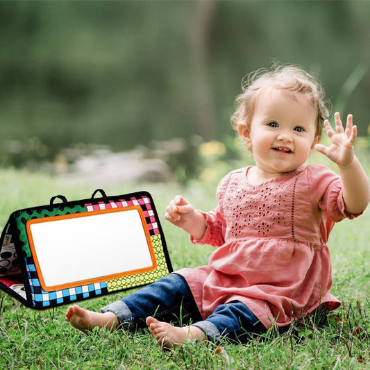 livre bebe tissu pres petite fille assise herbe