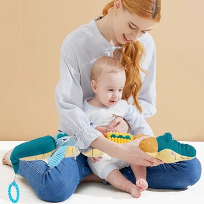 maman assise tailleur tient bebe regarde hochet crocodile sur maman
