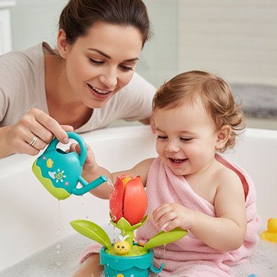 maman avec bebe verse eau sur jouet baignoire bebe