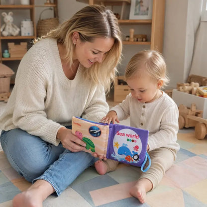maman bebe assis chambre regardent livre bebe en tissus