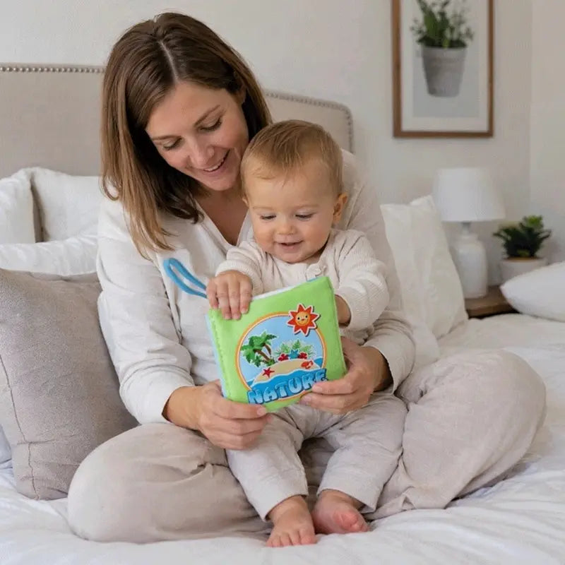 maman bébé assis lit regardent livre bebe en tissus