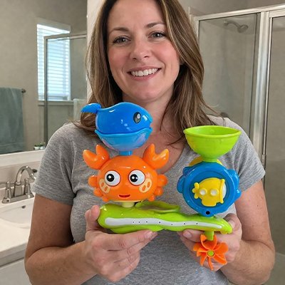 maman souriant et tient jouet baignoire bebe dans mains