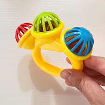 maman tient hochet bebe avec ses doigts