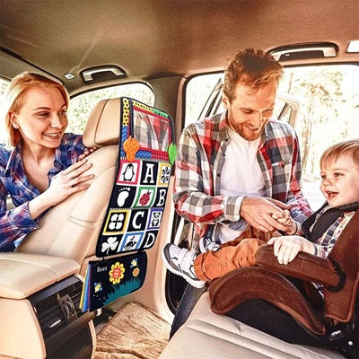 papa attache enfant dans siege auto face livre tissu bebe accroche derriere siege maman