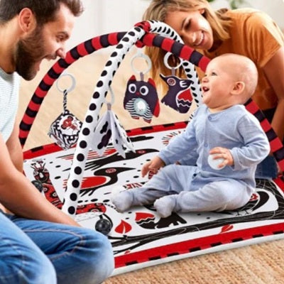 papa maman regarde bebe assis sur tapis d eveil