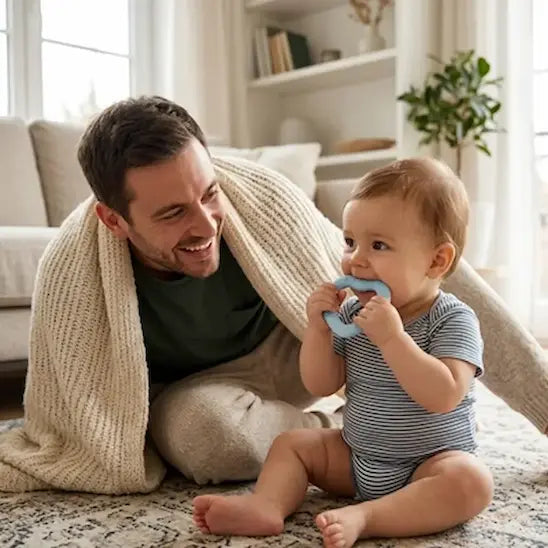 papa sourit bébé assis tapis mordille anneau dentition bébé bleu