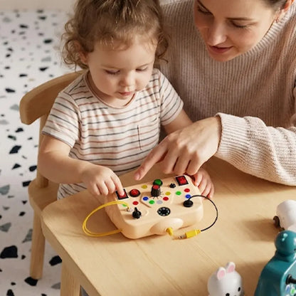 petit maman joue busy board bebe pose table