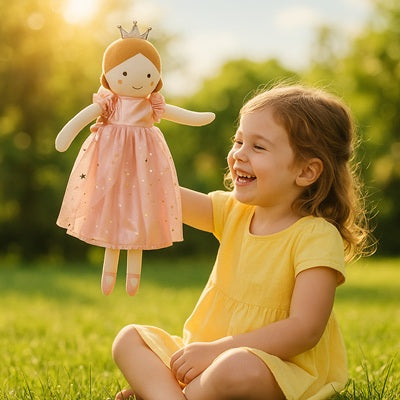 petite fille assise dans l herbe joue avec peluche doudou