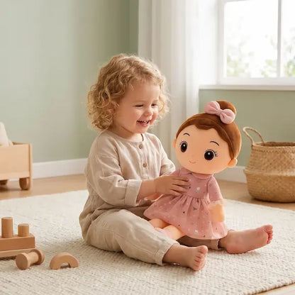 petite fille deux ans joue poupée de chiffon robe rose