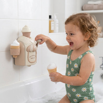 petite fille joue jouet baignoire pour bebe tient corne mousse