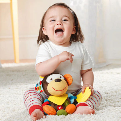 petite fille joyeuse assise joue avec peluche hochet