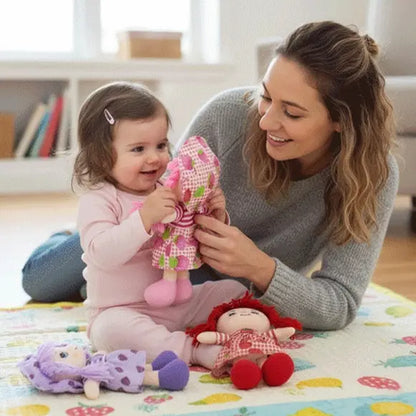 toute petite fille regarde poupée de chiffon maman sourit